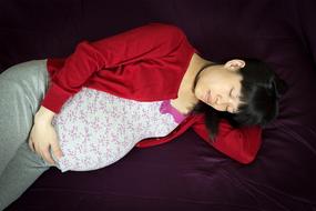 pregnant woman sleeping on the bed