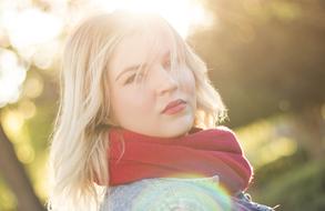 blonde with a red scarf on the background of the sun