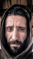 head of a man with a beard in a hood