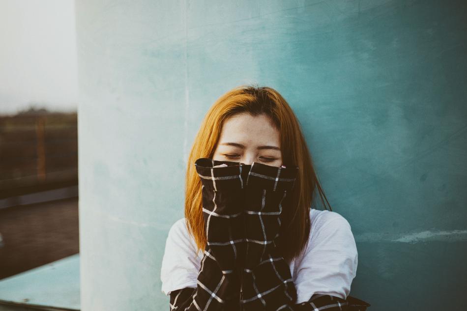 beautiful girl in a plaid jacket near the wall