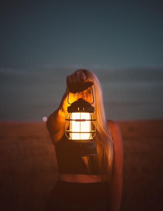 Girl with lantern in hand at dusk