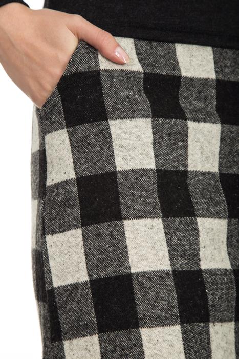 Hand in the pocket of the colorful, checkered skirt of a woman