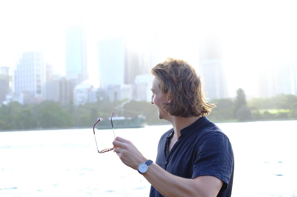 stylish man with glasses on the background of skyscrapers in the haze