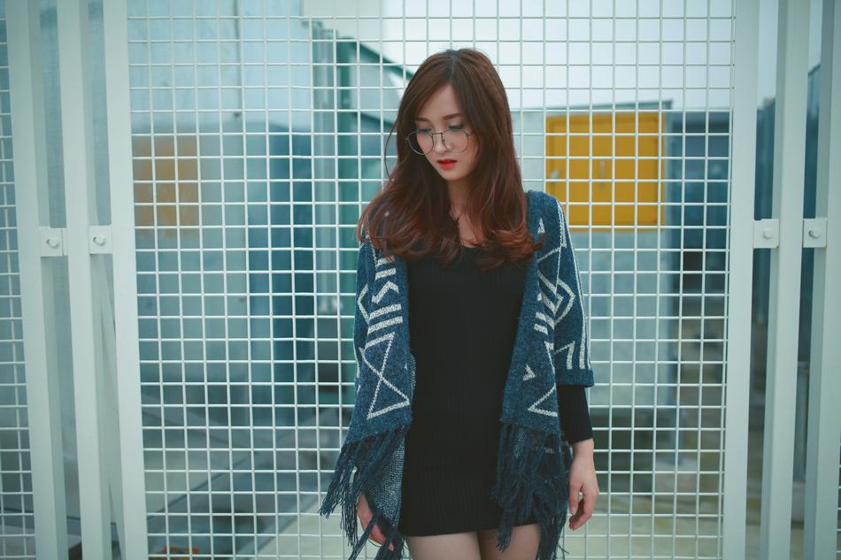 Girl in casual clothing in front of metal grid
