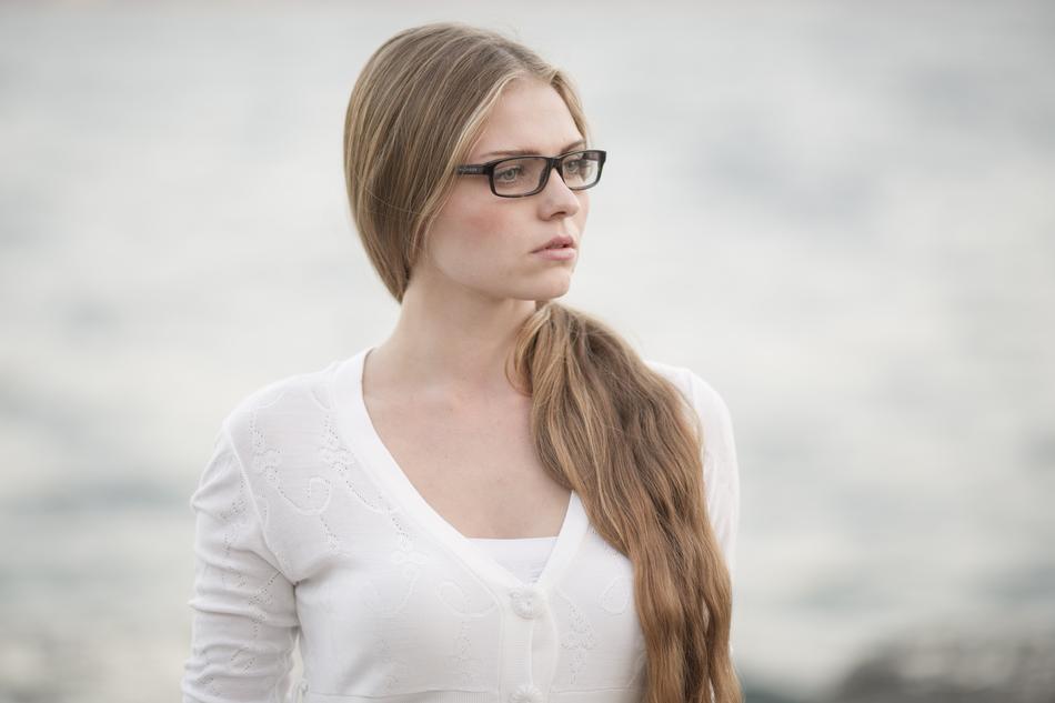 pensive blonde with glasses on a blurred background