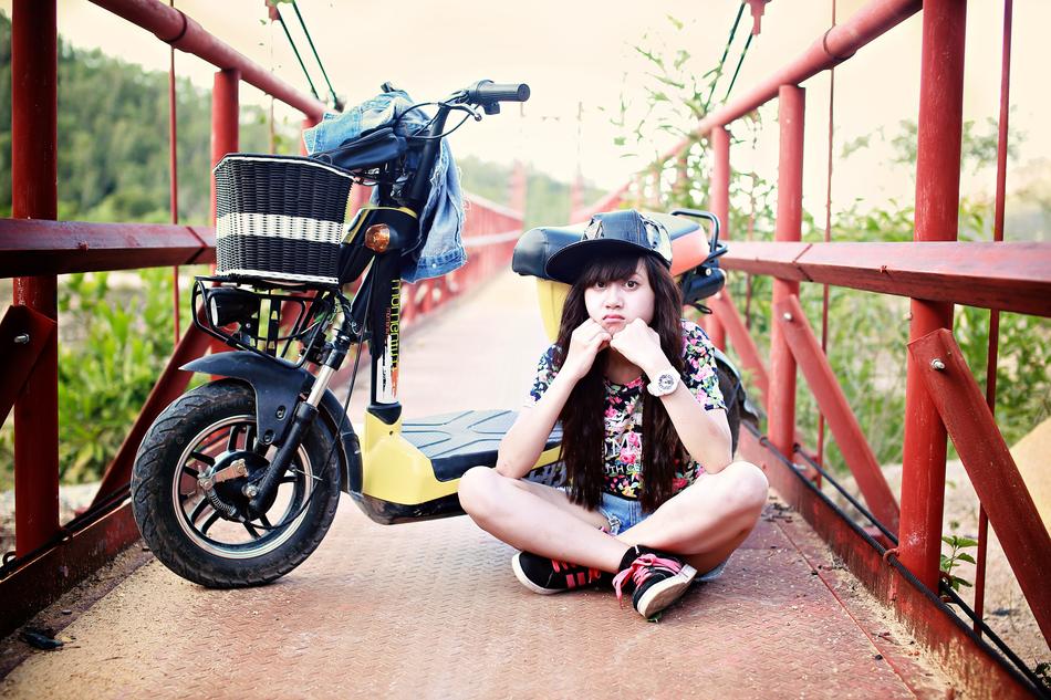 teenage girl and moped on the bridge