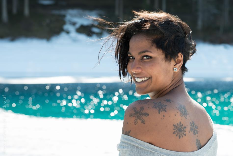 happy girl in tattoos posing on blurred background