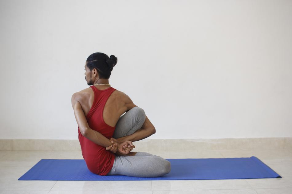 Yogi man with beard, doing exercise on the mat