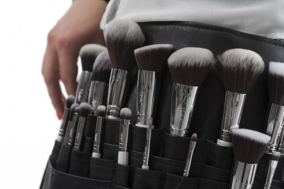 Close-up of the makeup brushes in the pockets of the person