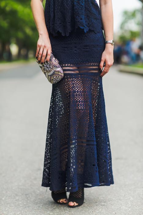 model in guipure dark blue dress with clutch