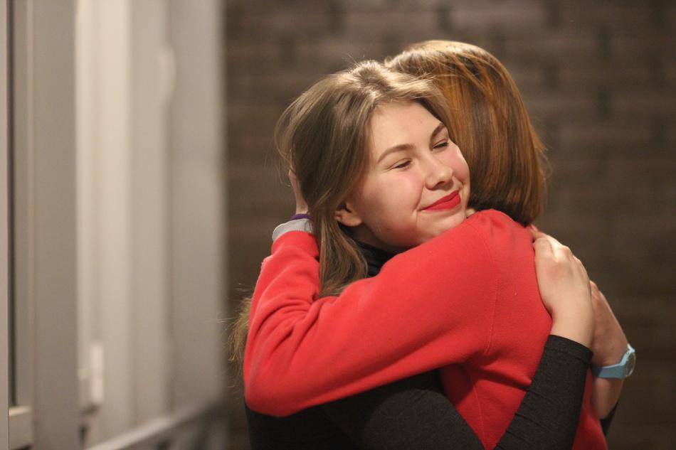 Smiling woman hugging with the other woman