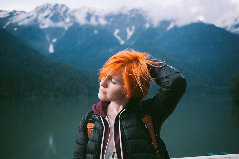 girl with red hair on a background of mountains