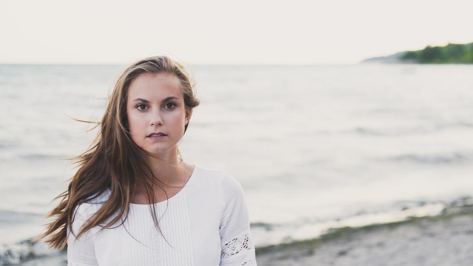 Portrait of the girl in white clothing, on the beautiful beach, with the waves