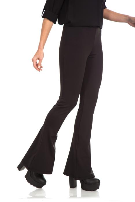 womanâs legs in black bell bottom trousers