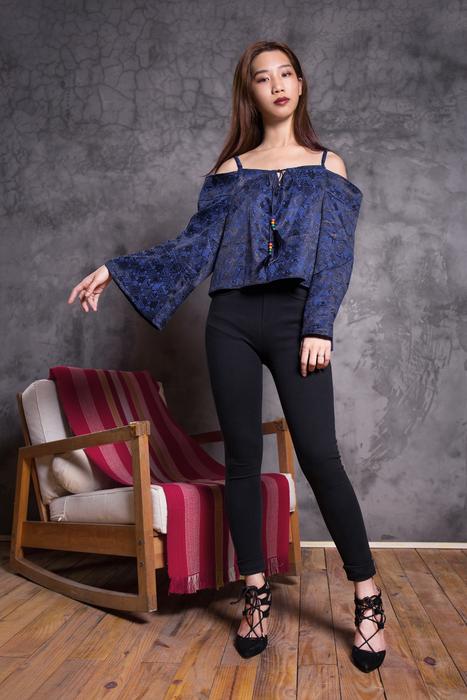 Asian girl in high-heeled shoes, posing near the colorful armchair