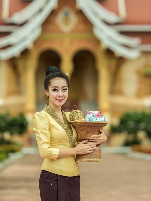 Asian girl, holding basket with the colorful packages, near the colorful building