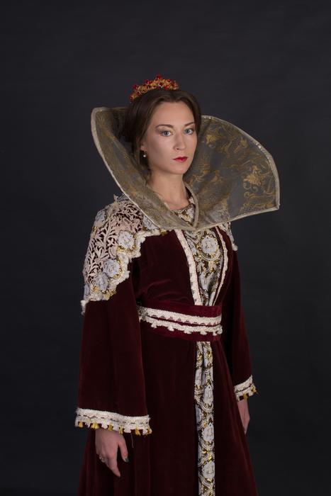 Woman in the colorful, vintage Queen dress, at dark background