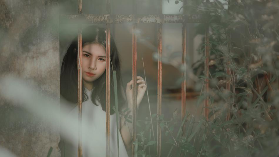 brooding brunette behind the fence