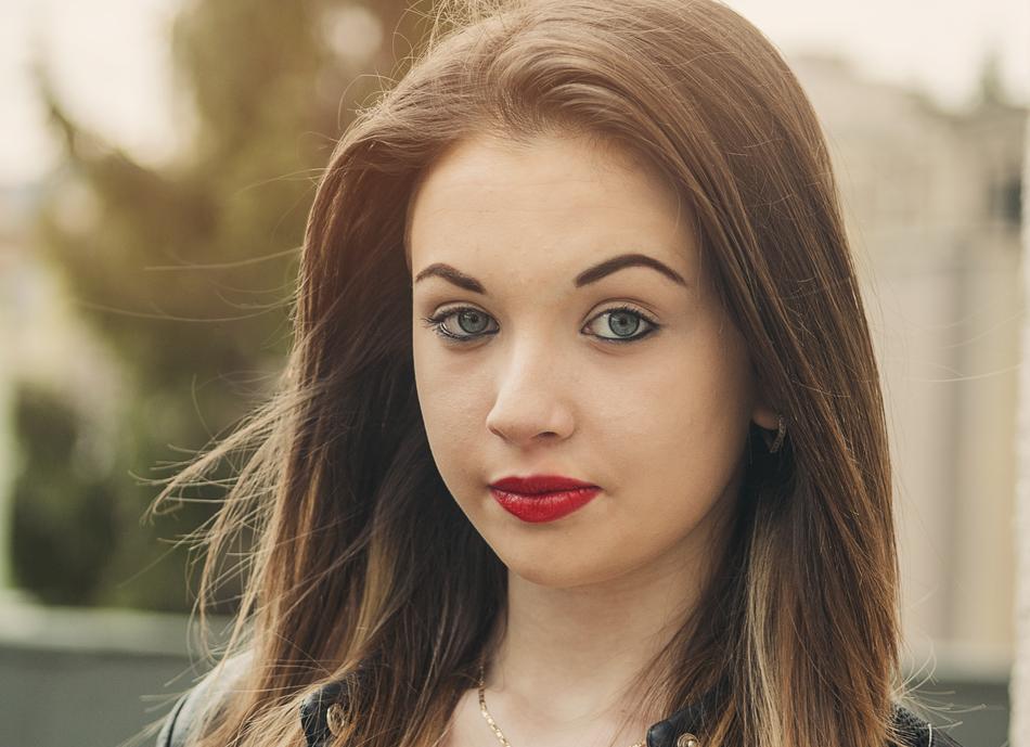 Portrait of the girl with colorful make-up, in light, at blurred background