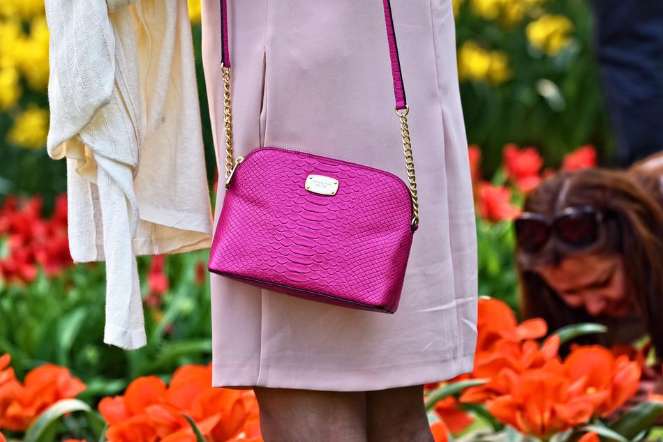 woman with elegant pink handbag in the garden
