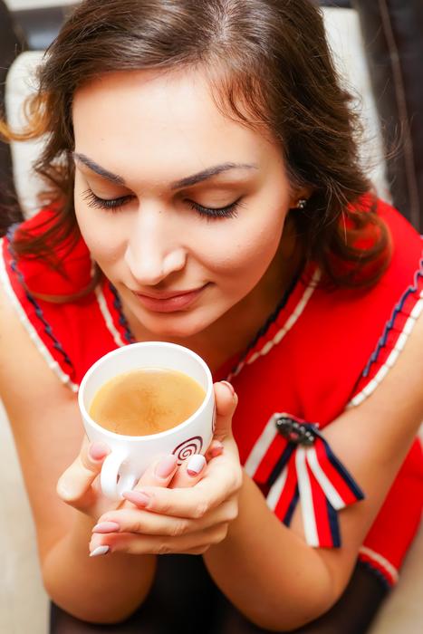 Woman smelling Christmas drink in the cup