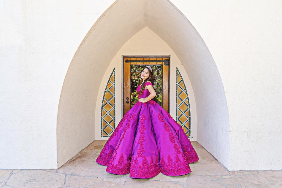 Beautiful, smiling girl in the colorful dress on QuinceaÃ±era, near the colorful architecture