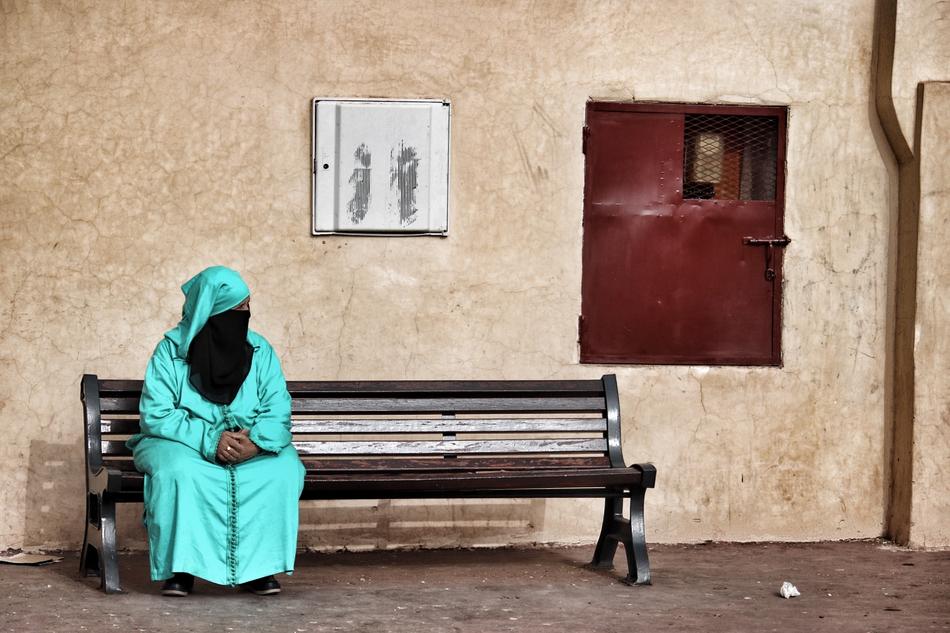 arab woman in traditional dress on a bench