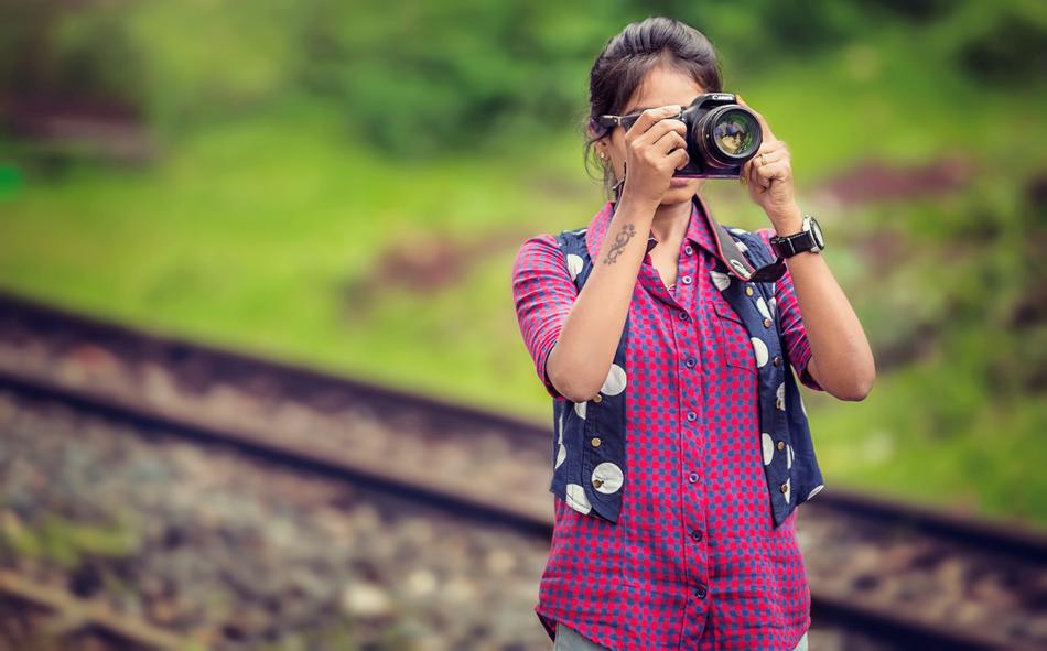 girl with camera on the railroad with blurred background