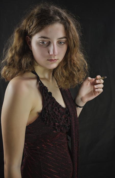 beautiful sad girl with cigarette at dark background