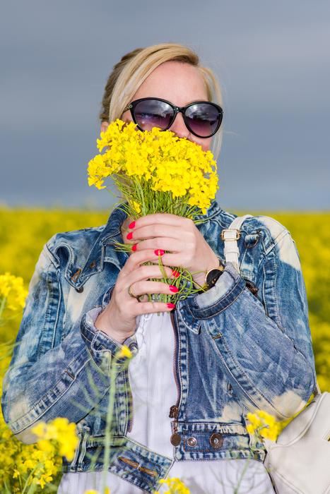 girl in a denim jacket with a bouquet of yellow flowers