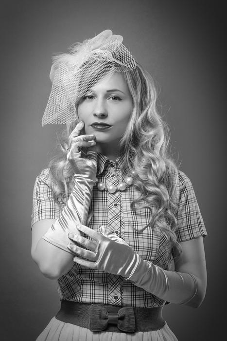 Black and white photo of the girl with make-up, in costume with gloves