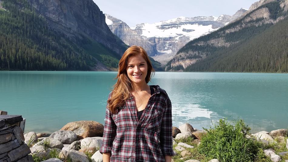 Beautiful, smiling girl, near the Lake Louise, among the mountains, in Canada