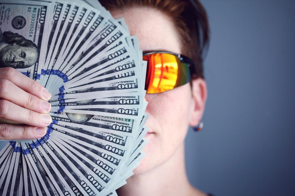Person in the colorful glasses, behind the fan of Dollar banknotes