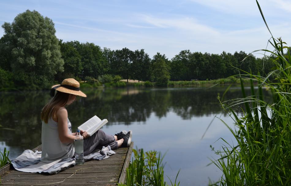 Reading book on Lake pier at Summer