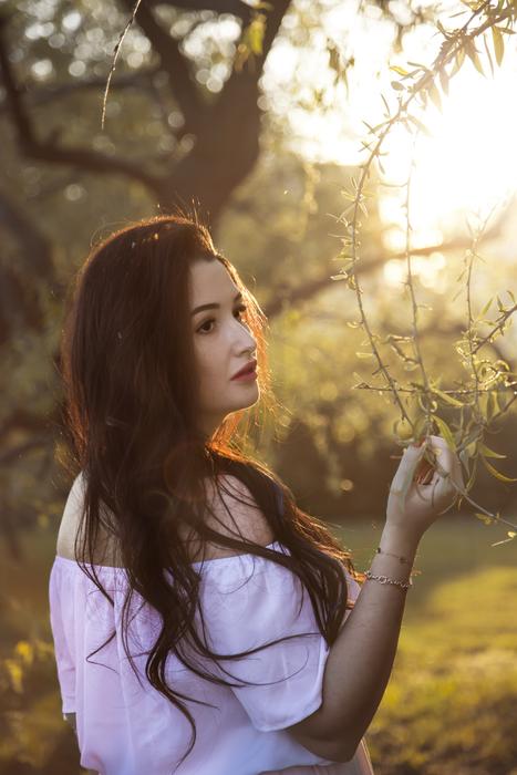 beautiful young brunette posing in nature in blurred background