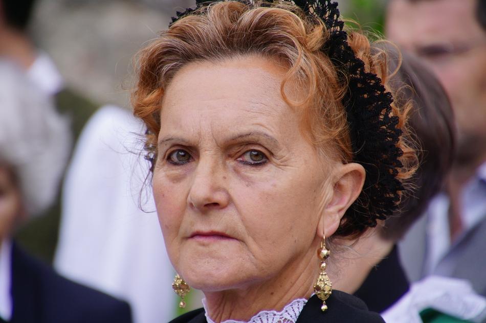 Portrait of the Tyrolean woman with earrings, among the people, in Altoadige, Italy