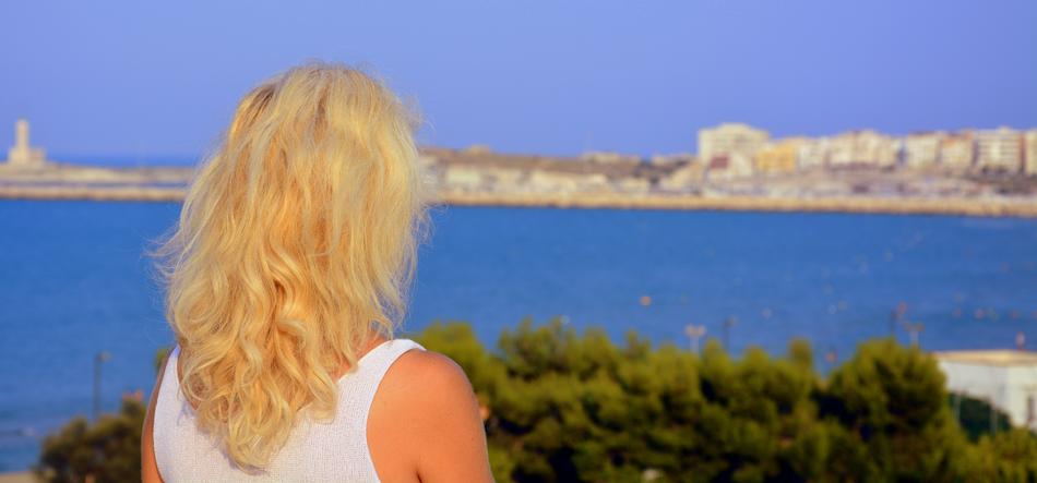 blonde on the coast of italy in a blurred background