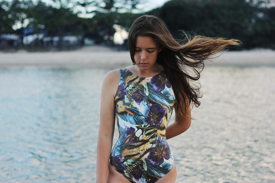 girl in a multicolored swimsuit on the coastline