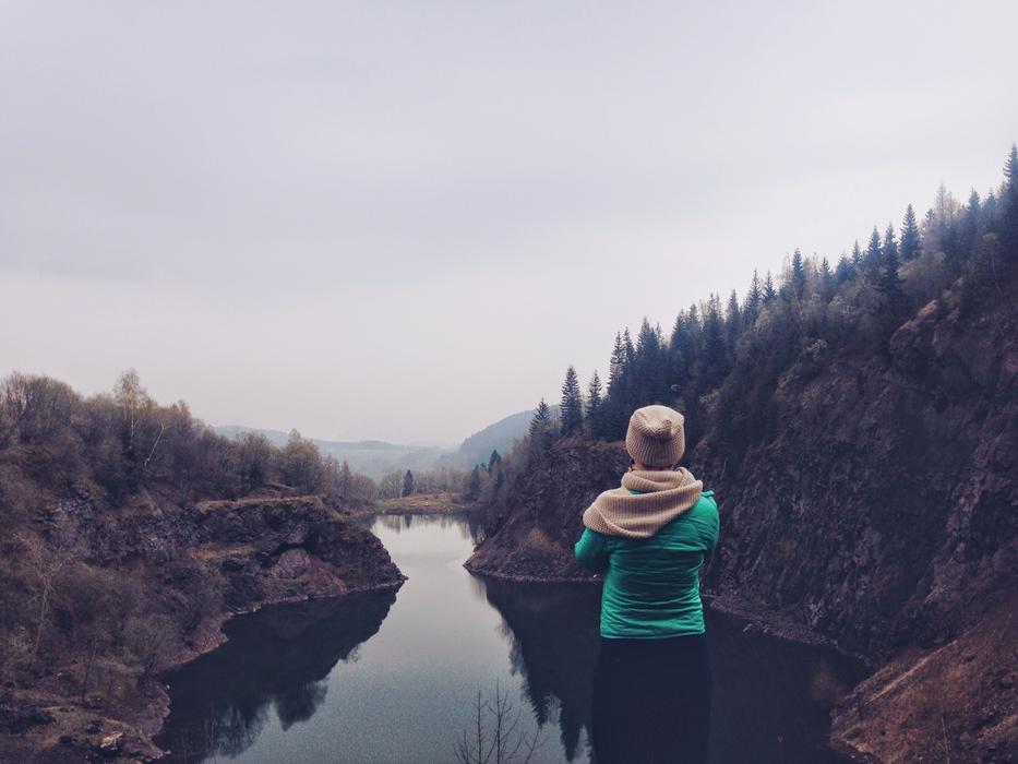 Girl in hat, on the beautiful landscape with the river, on the mountains with the colorful plants
