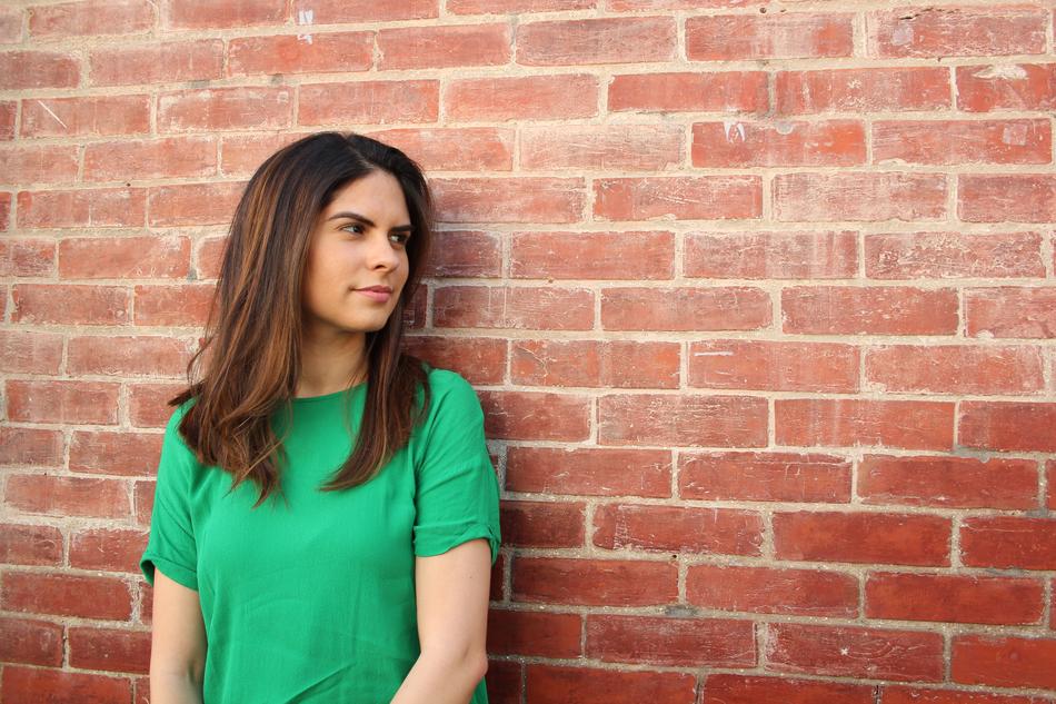 girl standing near a brick wall