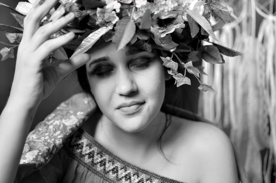 Black and white portrait of the woman with closed eyes, with the beautiful flowers and leaves