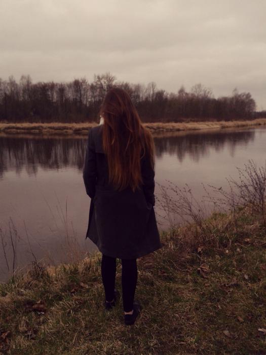 Girl on the shore of the river with plants
