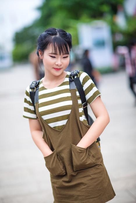 Portrait of the smiling girl near the other people and green teees