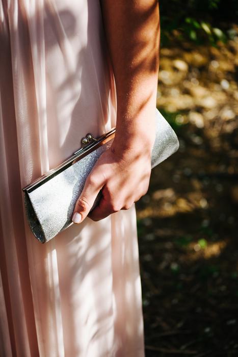 Girl in the dress, holding purse in the hand, in light and shadow