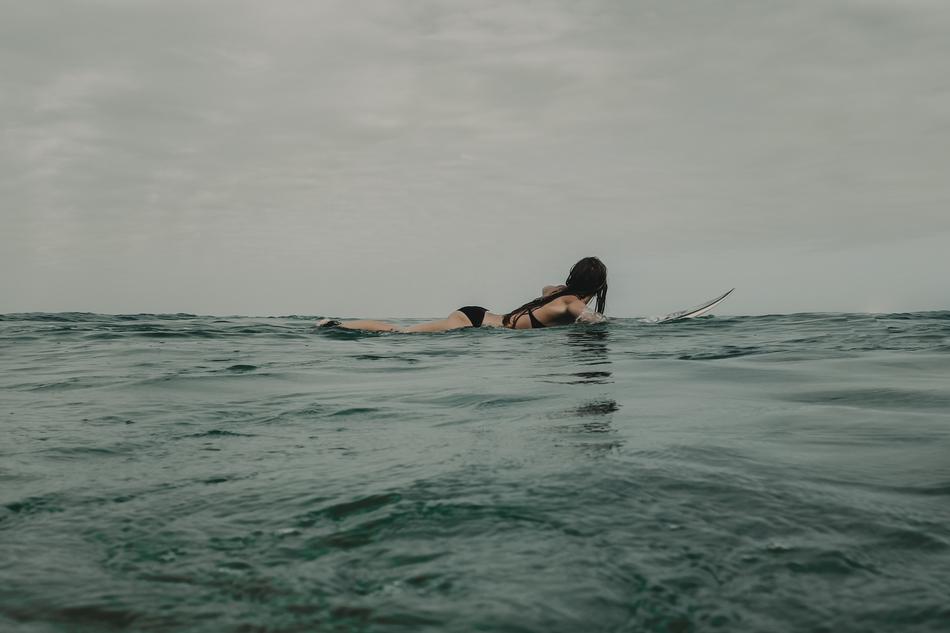 paddling woman in surfboard
