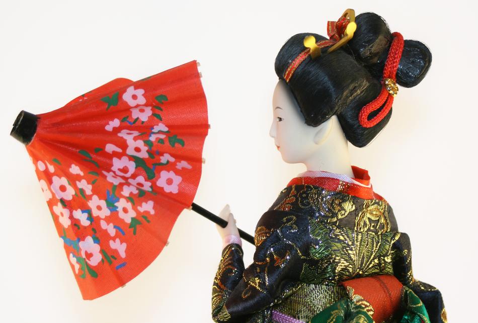 Colorful figure of Geisha, with umbrella, at white background