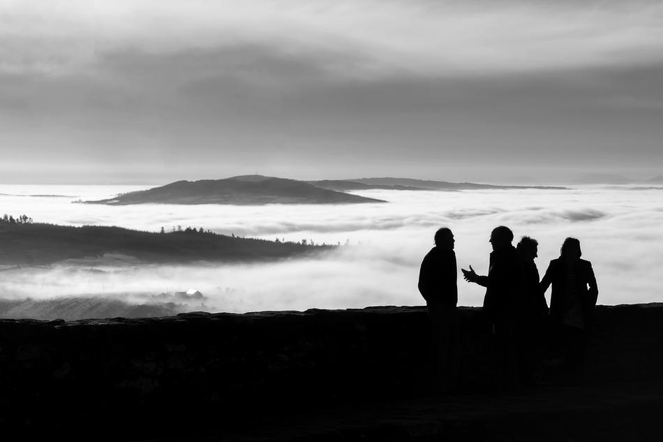 Silhouettes of the people, on the beautiful landscape with mountains in clouds