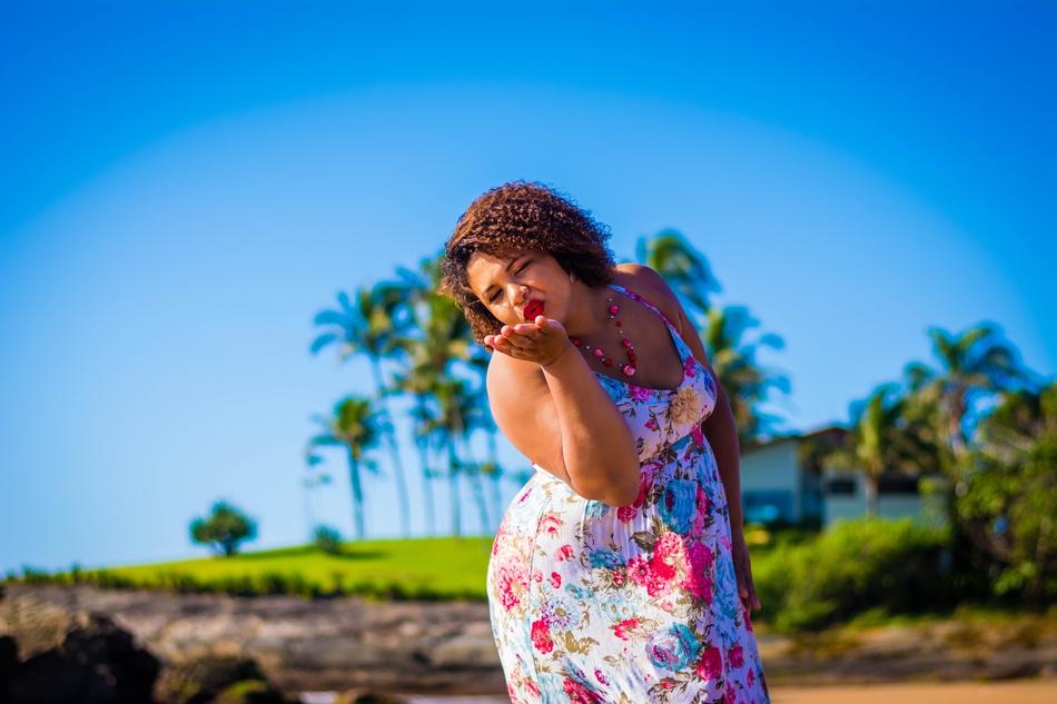 a woman in a flower dress sends an air kiss