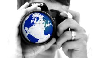 Earth icon on the "Canon" camera in woman's hands, in black and white colors, clipart