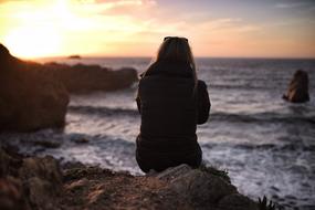 Girl on beach by the Ocean at Sunset